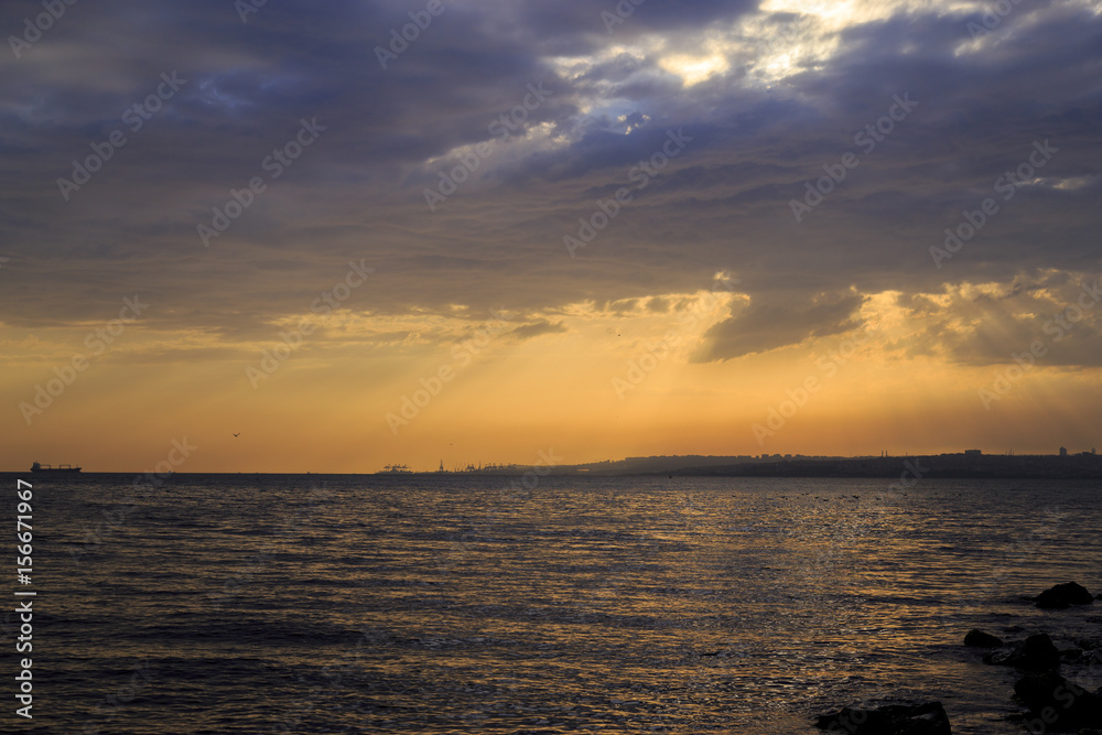 Fototapeta premium Empty cloudy sky from orange to blue with sun rays during the sunset