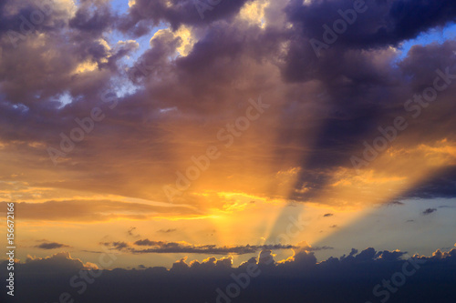 Empty cloudy sky from orange to blue with sun rays during the sunset © Solidasrock
