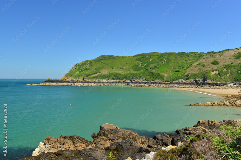Giffard Bay, Jersey, U.K.  Wide angle image of a coastline in the Summer with tropical teal seas.
