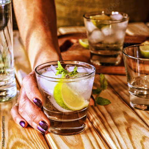 Female bartender offers alcoholic cocktail or non-alcoholic refreshing drink, cocktail, mohoto photo