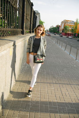 Walking in the city Beautiful blonde girl walking for the camera in an urban contest with city building in the backgroundstreet photo