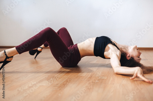 A young dancer practicing dance moves lying on her back in a dance class. Dance training photo