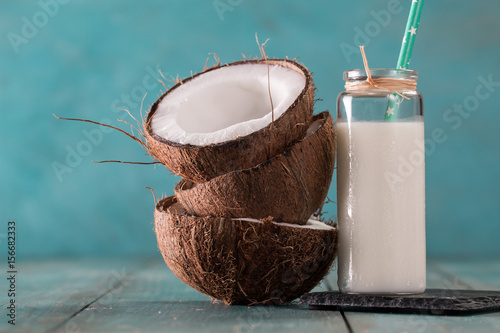 Coconut and coconut vegan milk non dairy on blue background with copy space