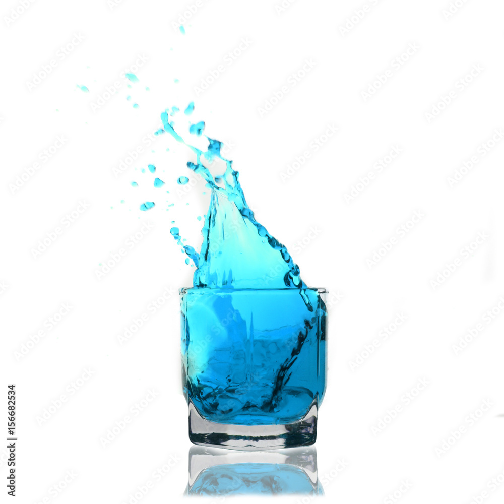 light-blue cocktail splashing on a glass on white background light-blue cocktail splashing on a glass on white background
