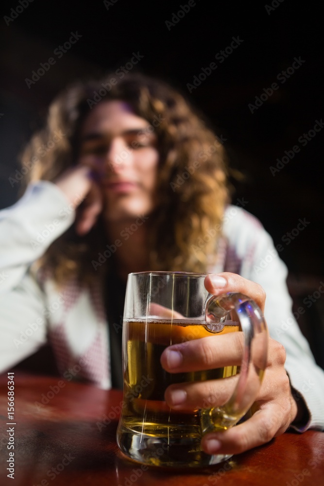 Man holding beer mug in bar