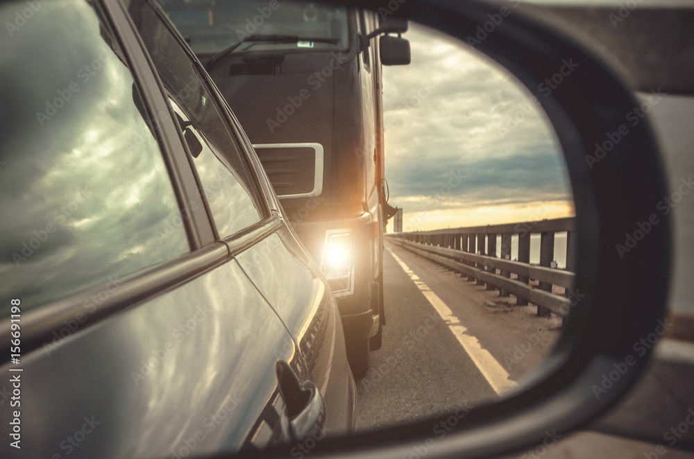 Reflection in the rear-view mirror of the car, the cargo with the lights on.