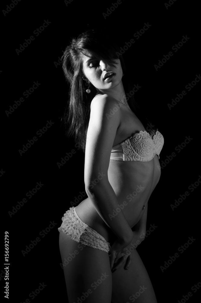 Fototapeta premium young beautiful female posing in white underwear. monochrome image