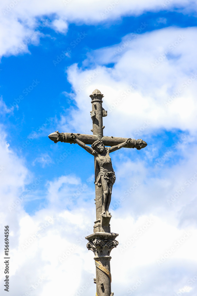 Crucifix on a blue sky background in Lourdes, France