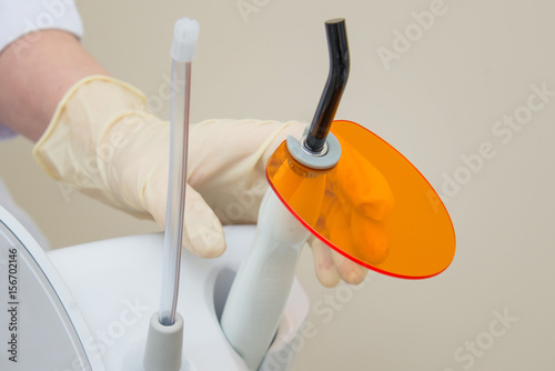 Nurse holding Dental UV curing light lamp . Ultraviolet polymerization lamp with Orange blocking glass. photo
