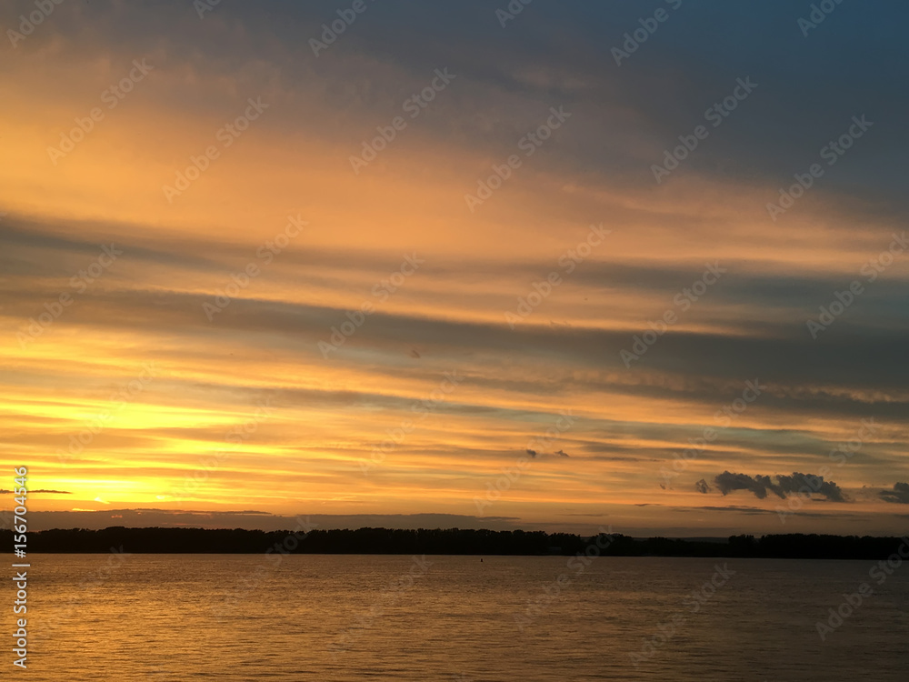 Красивый огненный оранжевый багровый закат на реке Волга