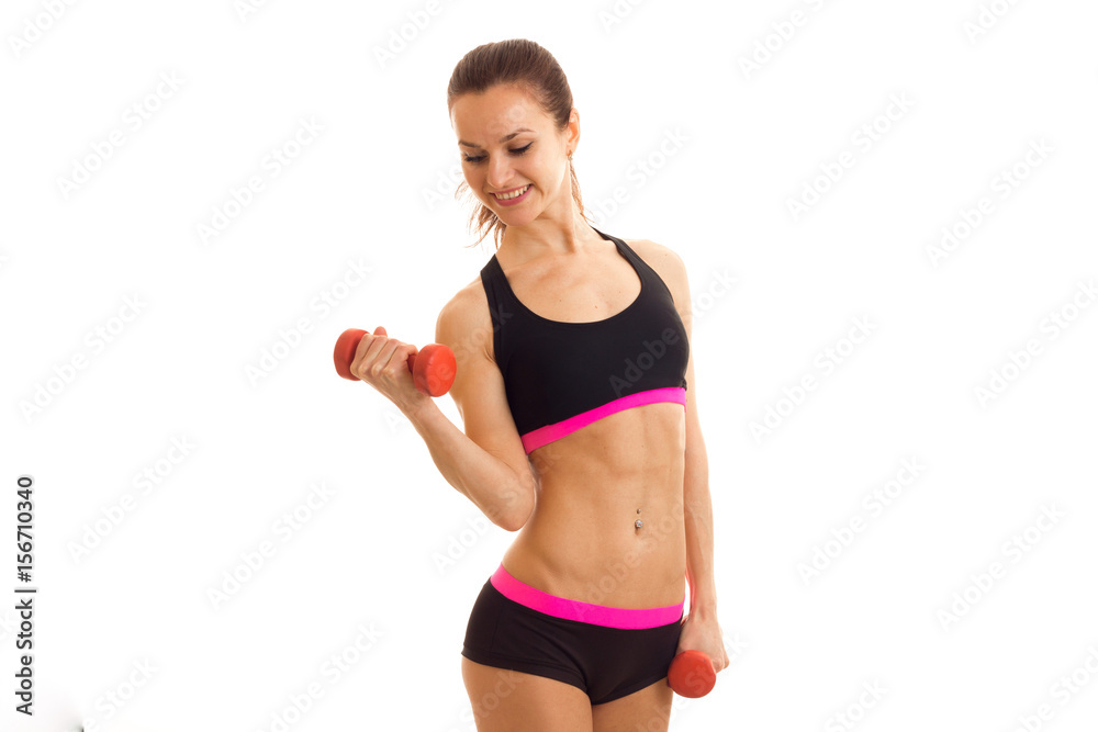 cute young athlete holding a dumbbell and smiling cute young athlete holding a dumbbell and smiling