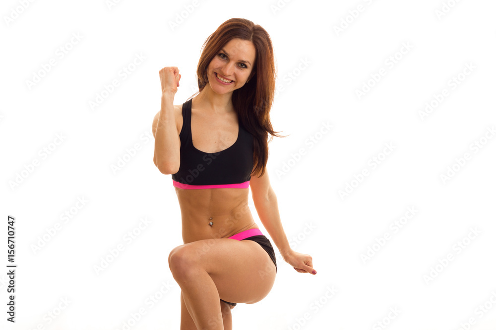 beautiful young athlete is smiling looks straight and makes fitness exercise beautiful young athlete is smiling looks straight and makes fitness exercise