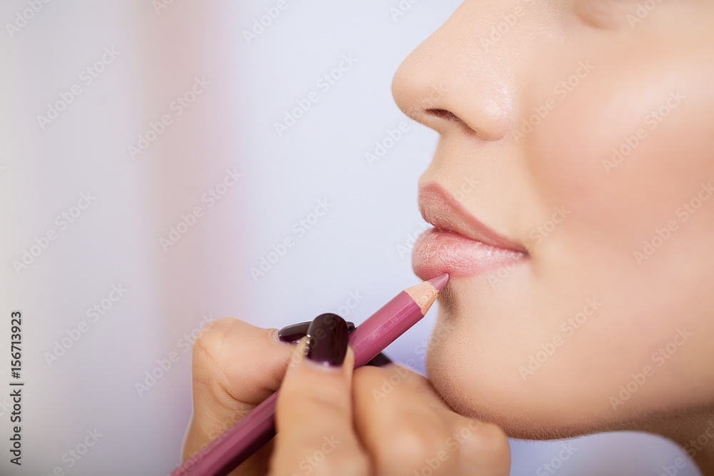 Professional makeup artist applying lipstick
