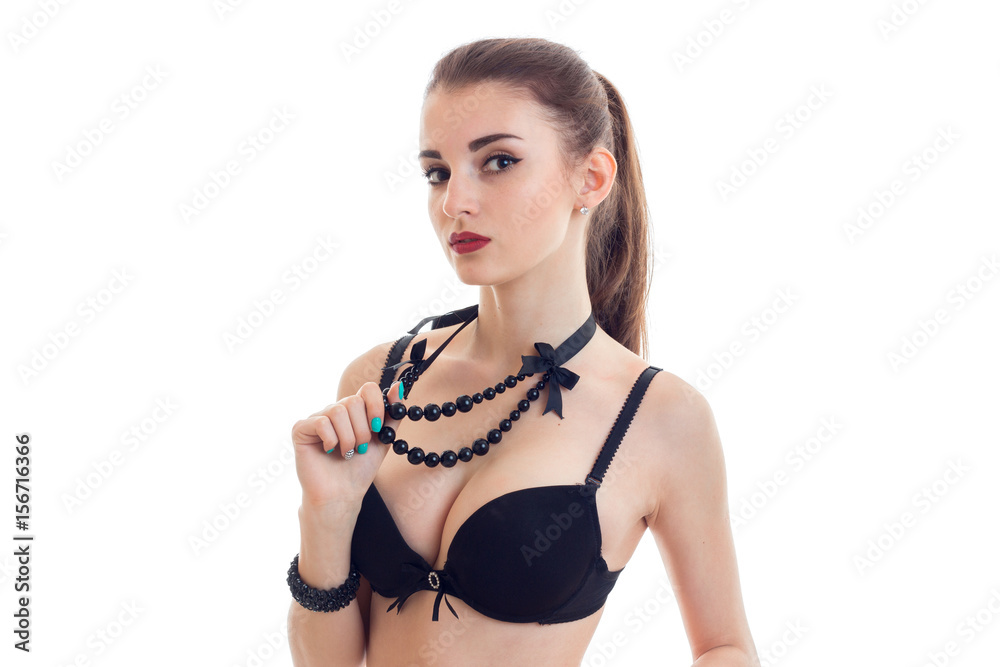 wonderful sexy girl in black bra sexy looks into the camera and holds hand  beads foto de Stock | Adobe Stock