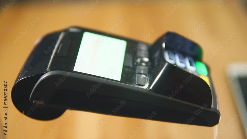 Close-up shot of a customer paying in the store with a contactless bank card and entering a pin-code. NFC technology Close-up shot of a customer paying in the store with a contactless bank card and entering a pin-code. NFC technology