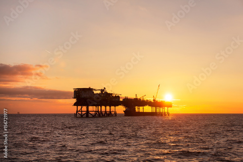 An offshore oil installation and a platform supply ship at sunset time © Lukasz Z