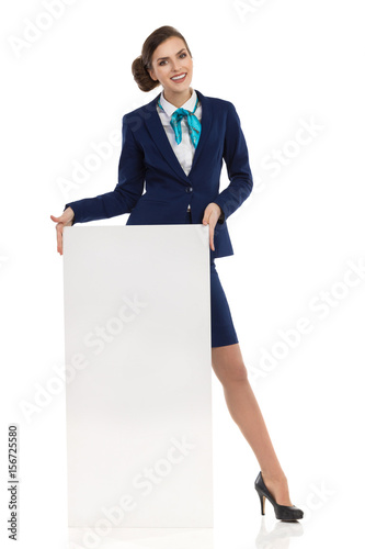 Smiling Cabin Crew Woman Is Standing Behind Poster