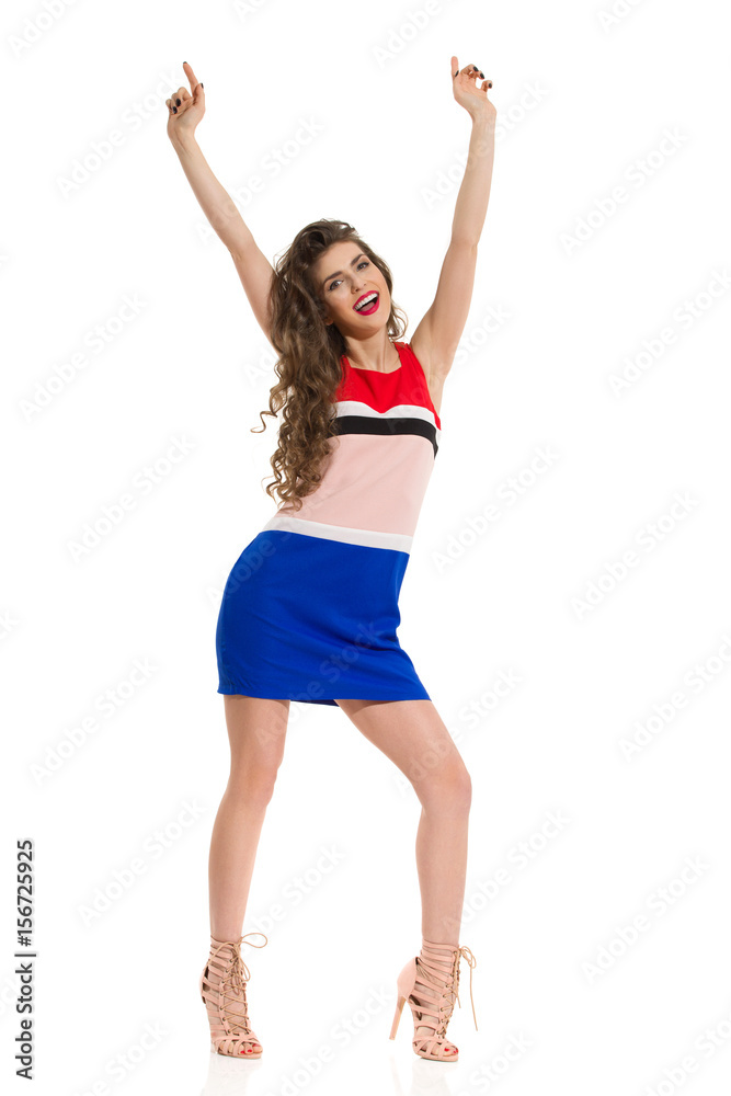 Fashion Model In Mini Dress And High Heels Is Posing With Arms Raised