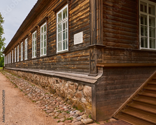 The merchant's house/Wooden merchant's house. One floor. Steps, a porch. Many windows. The basement is made of stone. Russia, Pskov region, summer.