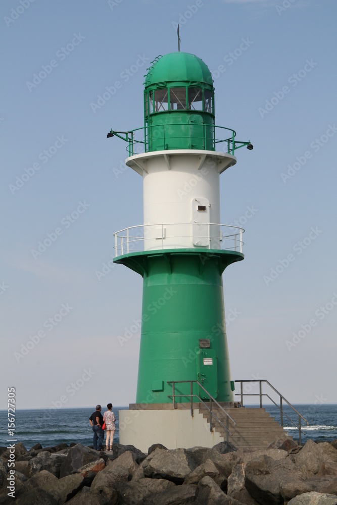 Grün weißer Leuchtturm an der Hafeneinfahrt in Warnemünde