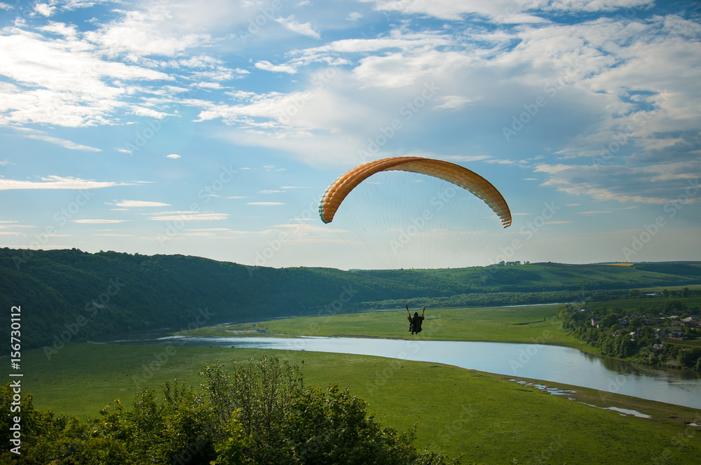 Paragliding over the river valley in summer sunny day. Dniester river, Ukraine. Paragliding over the river valley in summer sunny day. Dniester river, Ukraine.