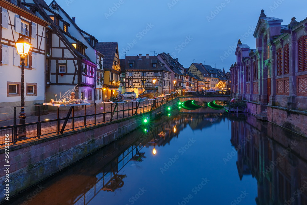 Traditional Alsatian half-timbered houses on the channel in Petite Venise, old town of Colmar, decorated and illuminated at christmas time, Alsace, France