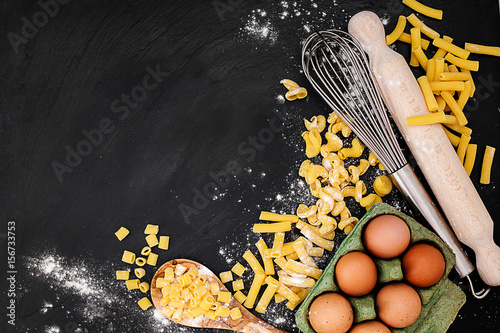 Obraz na plátně fresh egg pasta with ingredoents and kitchen utensil over slate