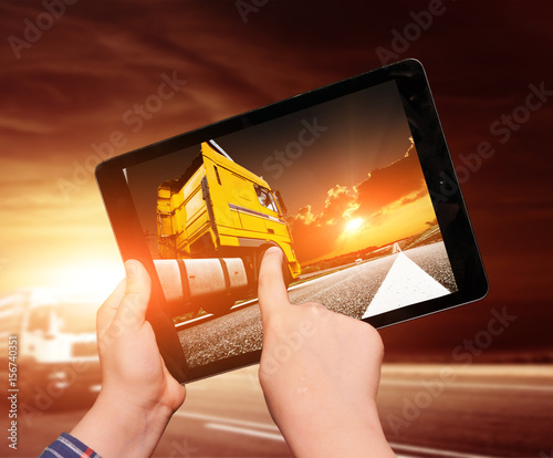 Tablet in hands with imageof truck photo