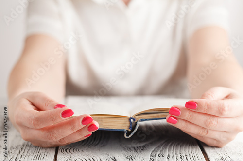 Woman sitting at a table reading a book