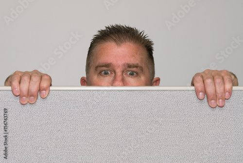 Canvas Print Man peering over office cubicle