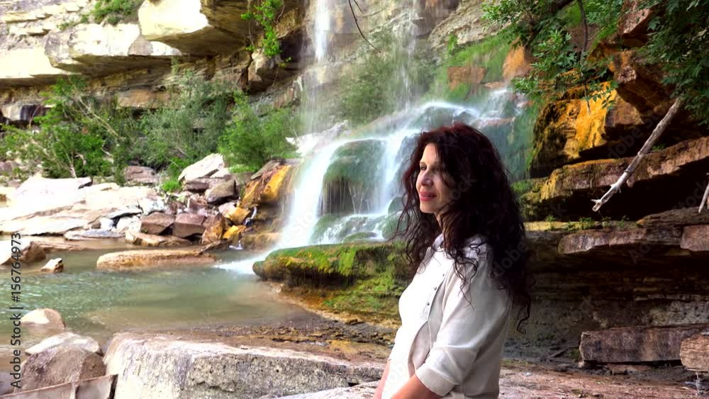 lady relaxing near waterfall on duck of river lady relaxing near waterfall on duck of river