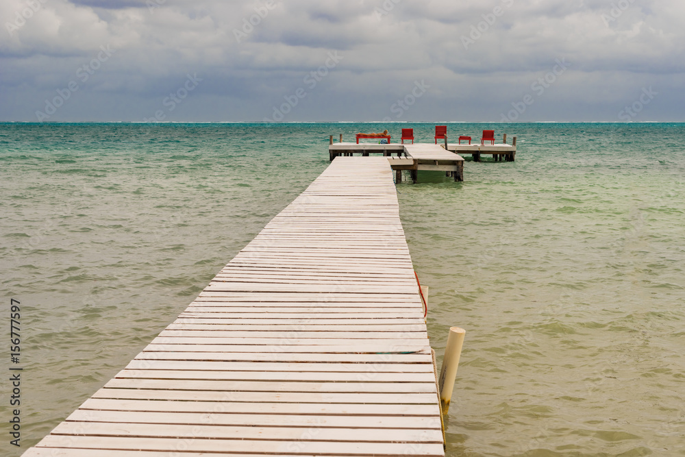 Wooden pier dock and ocean view at Caye Caulker Belize Caribbean.