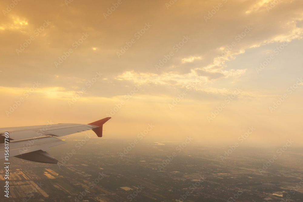 Wing of airplane flying above the clouds .