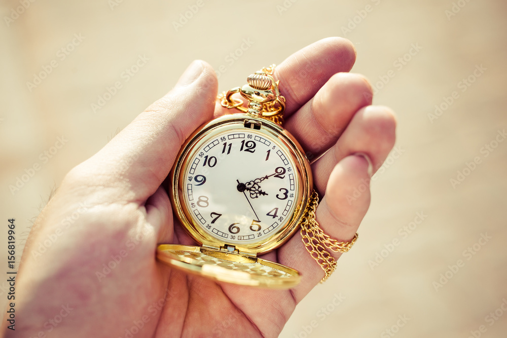 Golden pocket watch in hand close up. Golden pocket watch in hand close up.