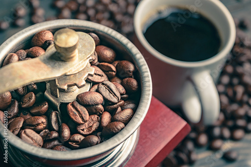 close up coffee bean in grinder and cup