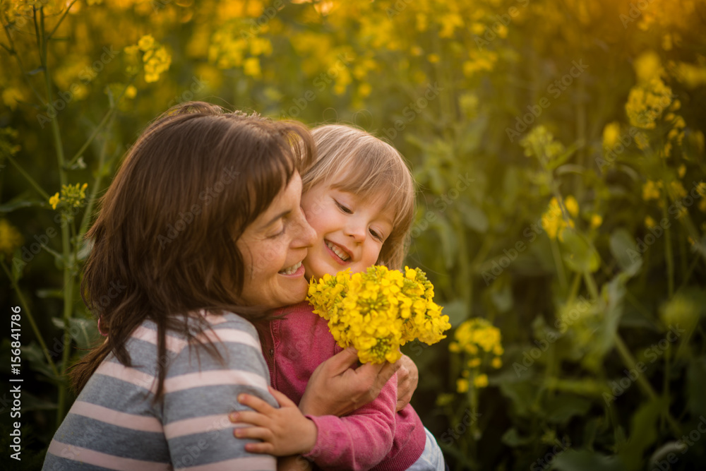 Smiling woman embracing her cute daughter, outdoors. Smiling woman embracing her cute daughter, outdoors.