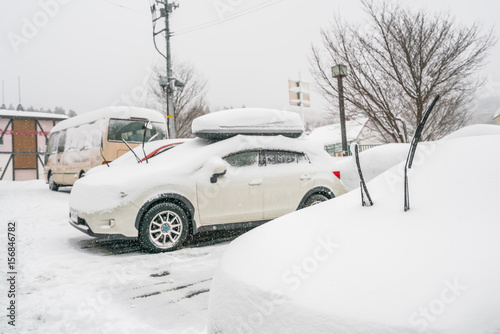 Cars covered with white snow in winter .