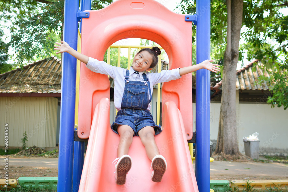 Asian girl playing in playground happy on holiday selective and soft focus Asian girl playing in playground happy on holiday selective and soft focus