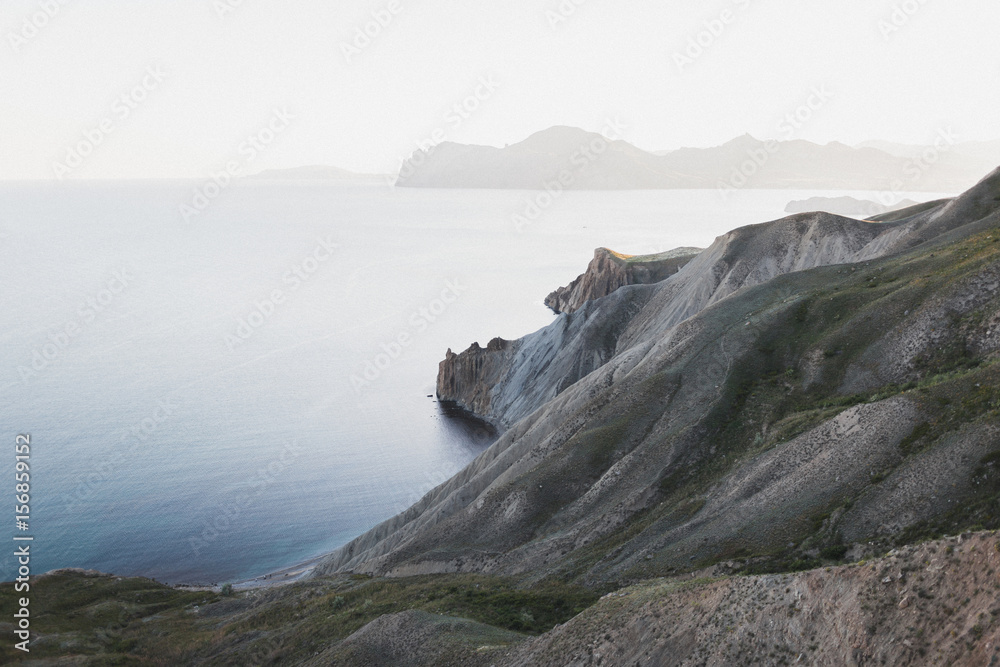 Sunset landscape overlooking the hilly coastal line in Crimea, Koktebel. Hills and silhouette of mountains on horizon