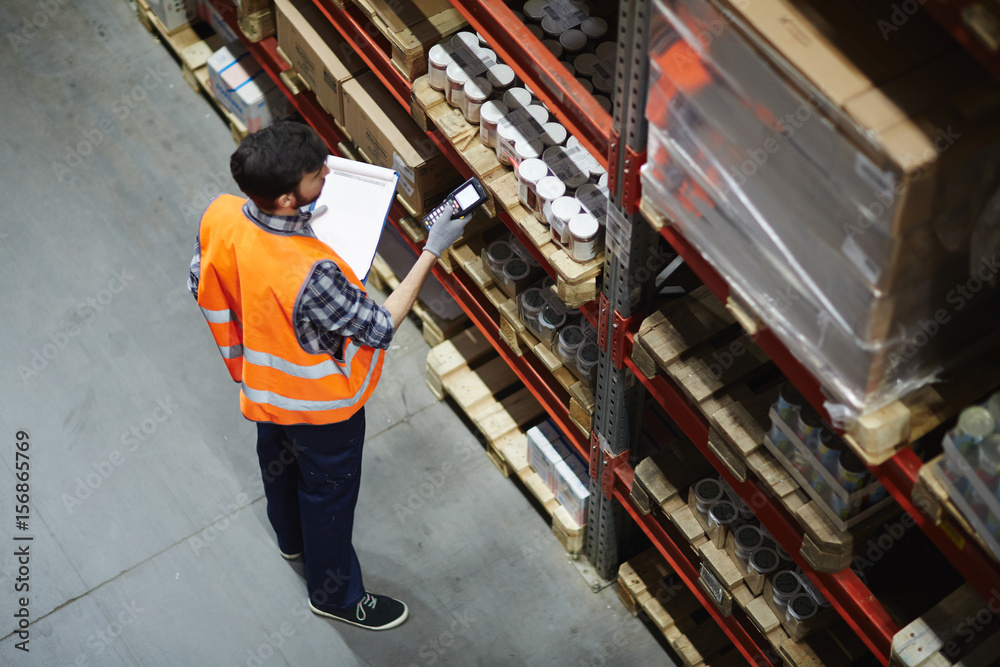 Logistics dispatcher scanning barcodes on packs with goods