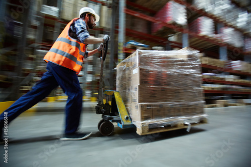 Papier peint Man in uniform pushing cargo on forklift