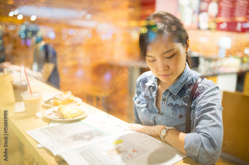 Asian woman reading magazine