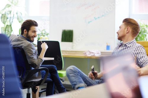 Young managers discussing news at break in office