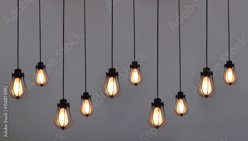 Beautiful hanging light bulbs on plain background for card, banner, wallpaper