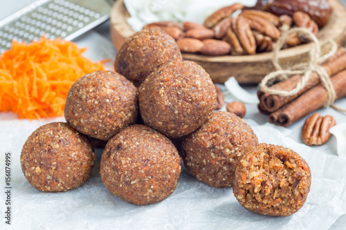 Healthy homemade paleo energy balls with carrot, nuts, dates and coconut flakes, on parchment, horizontal