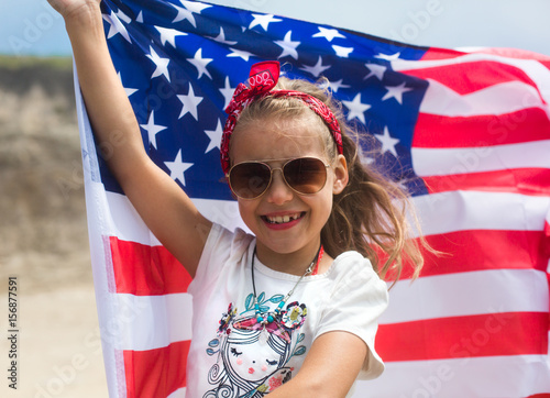American flag in hands of little girl on US Independence Day July 4th