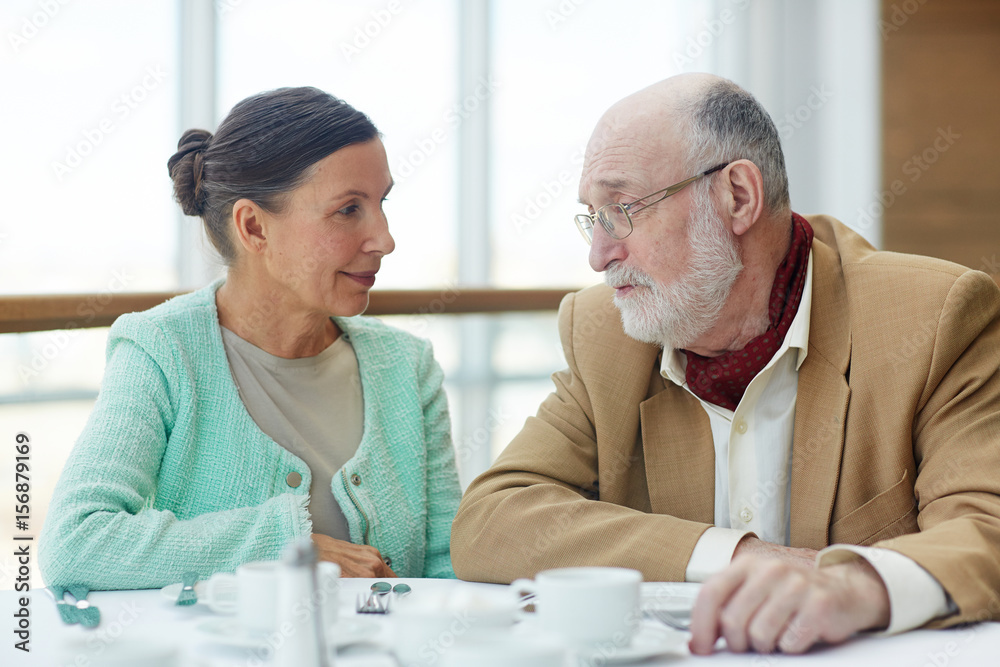 Fototapeta premium Senior couple talking by served table in cafe