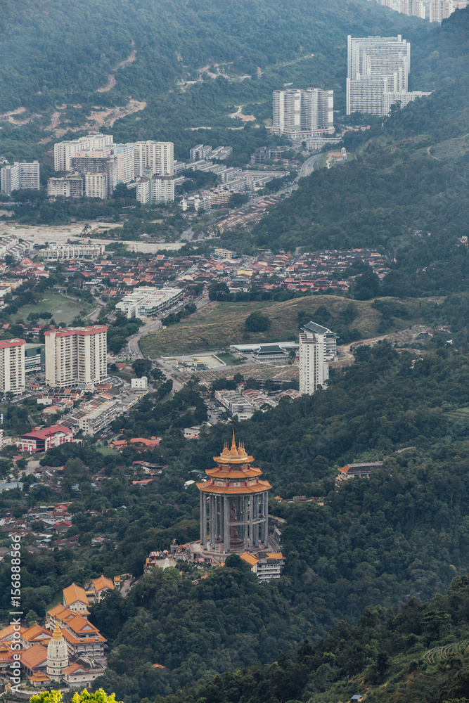 Cloudy sky, cityscape, Guayin octagonal pagoda and mountain with green that viewed from Penang Hill at George Town. Penang, Malaysia.