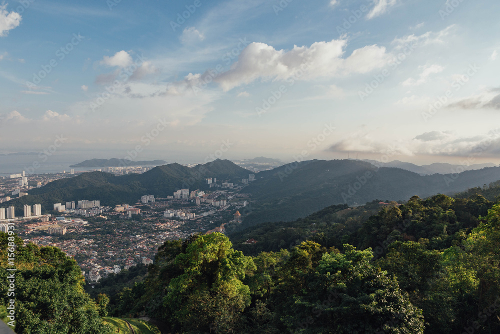 Fototapeta premium Cloudy sky, cityscape and mountain with green that viewed from Penang Hill at George Town. Penang, Malaysia.