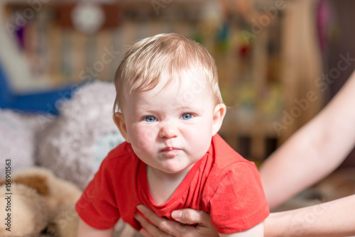 A baby child with blue eyes looks at the camera